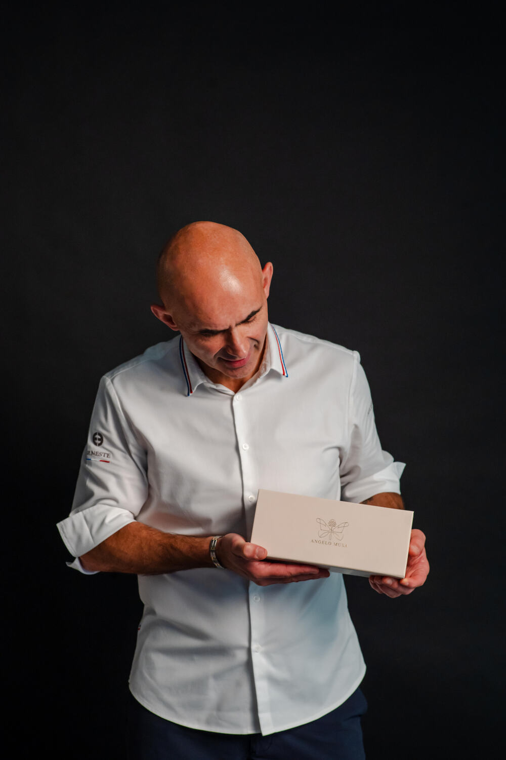 Chef Angelo Musa tenant une boîte signature, dans le cadre de sa collaboration pour la création et le développement de sa marque – packaging et storytelling par Art de Vivre by Candy - Crédit photo Marcio Serafim
